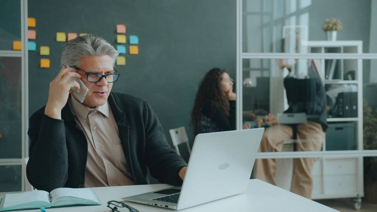 how to answer business calls professionally showing a clean desk setup with headset, notebook, and visible call script